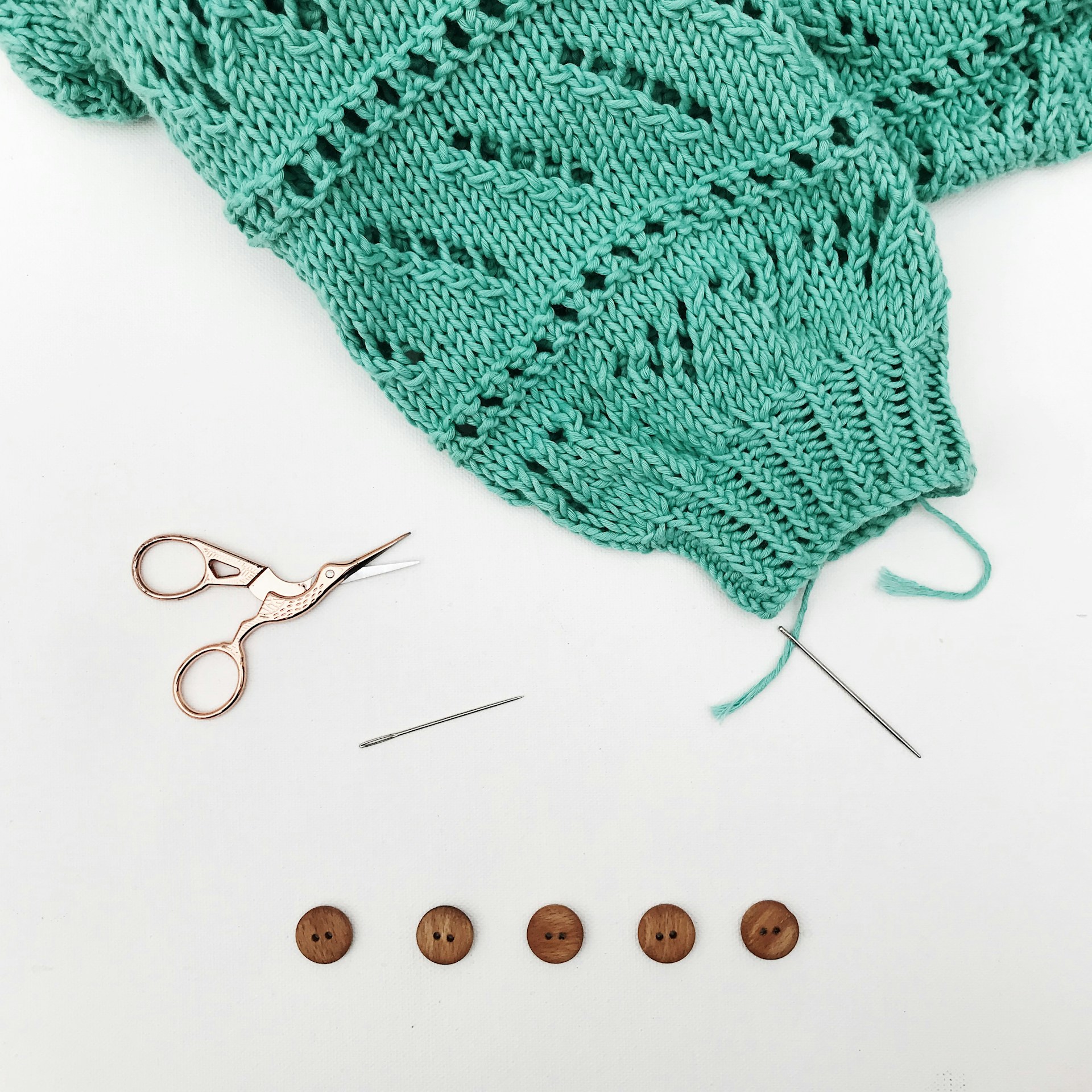 gestrickter Ärmel mit Nadel und Knöpfen